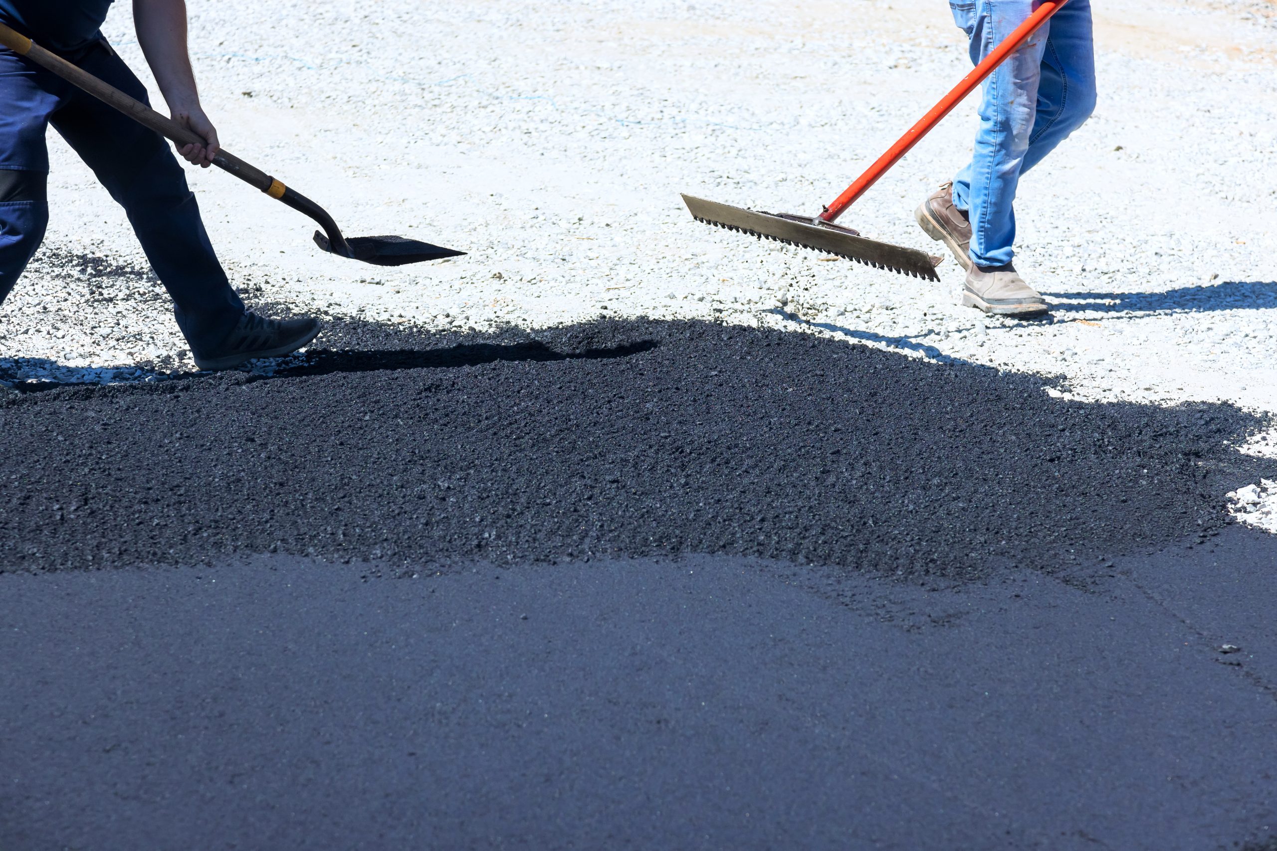 During reconstruction of street, a worker repairs damaged portion road